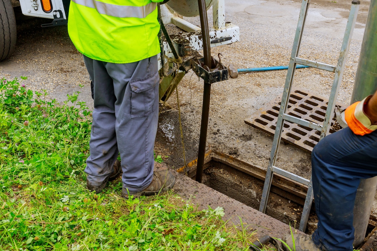 plumbing crew clearing an outdoor sewer line backup